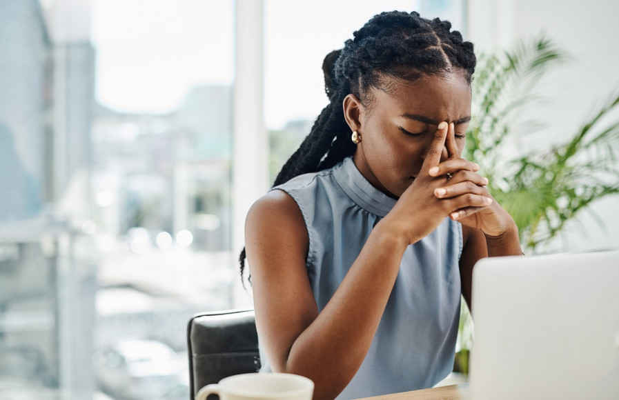 Woman placing her head in her hands looking stressed