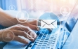 fingers typing on a computer with computer mail symbol