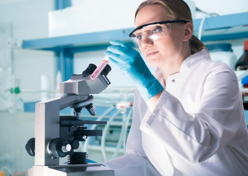 Female Scientist looking at test tube