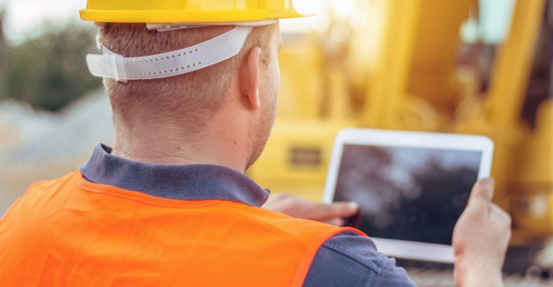 Man wearing safety gear using a laptop 