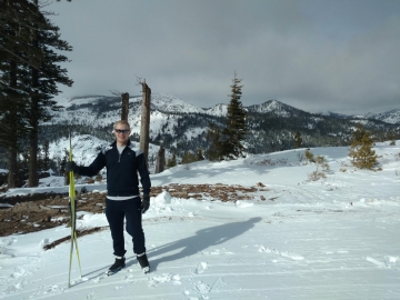 Man holding skis on a mountain