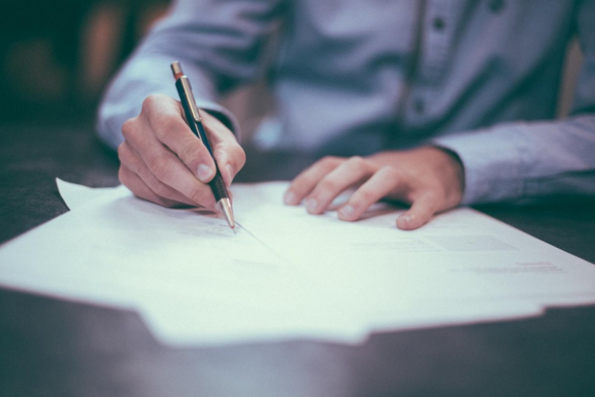 Person writing on documents