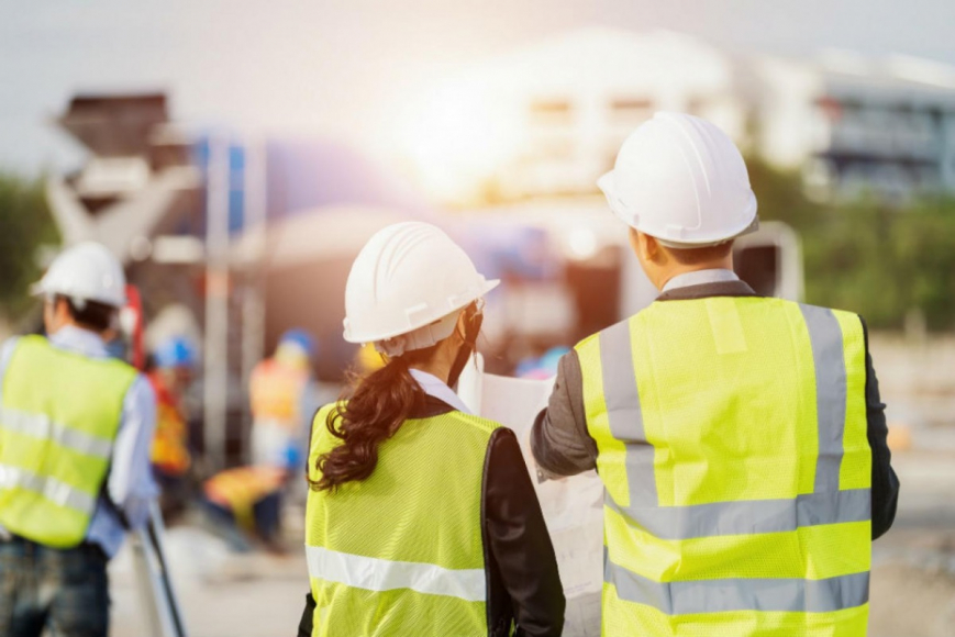 People in safety vests looking over plans
