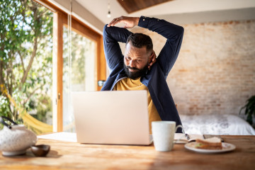 Male Employee Stretching at His Desk