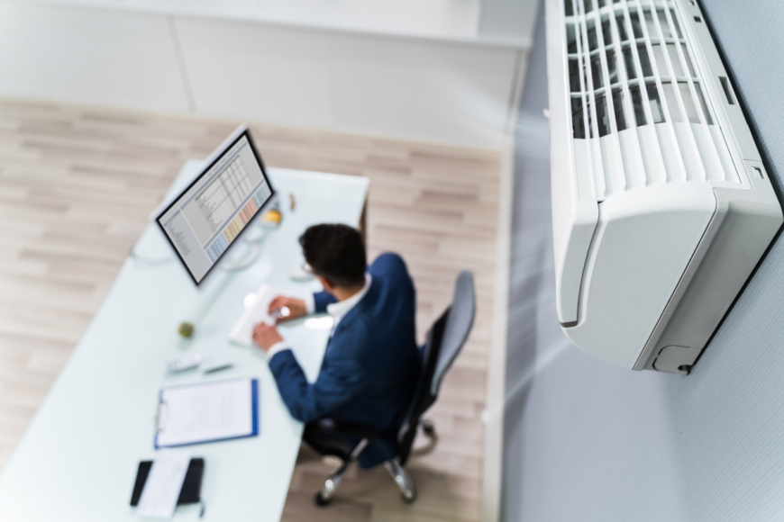 man sitting in office with air conditioner 