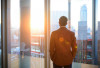 Man looking out window at city skyline